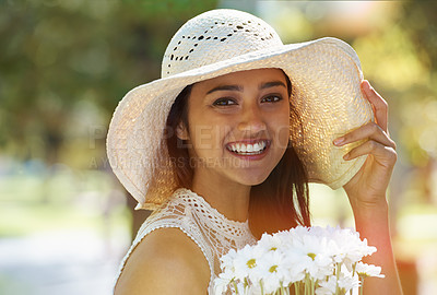 Buy stock photo Woman, portrait and flowers for relaxing in park or garden, smile and travel on summer holiday. Female person, peace and enjoy vacation in countryside, outdoors and hat on weekend adventure in nature