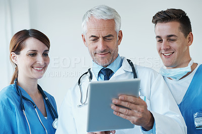 Buy stock photo Tablet, discussion and doctor with nurses in hospital for medical diagnosis or treatment meeting. Team, digital technology and senior surgeon talk to healthcare workers for surgery research in clinic
