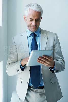 Buy stock photo Shot of a mature businessman using a digital tablet