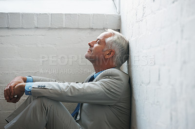 Buy stock photo A relaxed businessman sitting on the ground