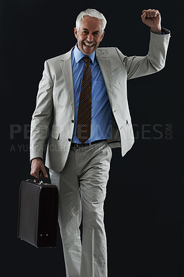 Buy stock photo Excited, portrait and senior businessman with suitcase in studio, celebration or winner fist on black background. Travel, success and elderly entrepreneur face with yes hands for opportunity or deal