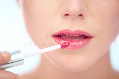 Buy stock photo A young woman applying pink lipstick with an applicator