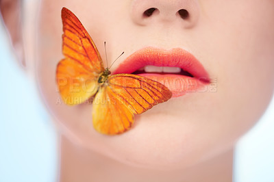 Buy stock photo Beauty, makeup and butterfly on lips of woman in studio on blue background for harmony closeup. Skincare, mouth and cosmetics with insect on face of model for natural wellness or skin treatment