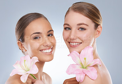 Buy stock photo Happy woman, portrait and skincare with flowers for natural beauty, makeup or cosmetics on a blue studio background. Young female friends or models smile in satisfaction for spa or facial treatment