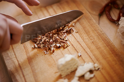 Buy stock photo Knife, person chop nuts and cooking, salad and healthy food for diet, nutrition and wellness at home. Meal prep in kitchen, wood board and prepare dish for lunch or dinner with closeup of ingredients