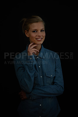 Buy stock photo A young woman standing with her hand on her chin wearing a denim shirt