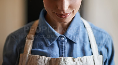 Buy stock photo A young woman wearing an apron