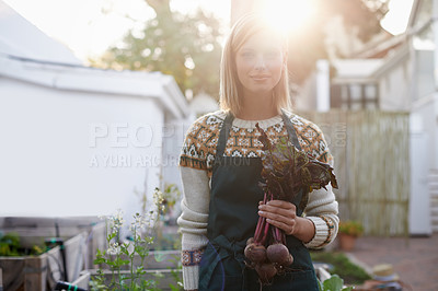 Buy stock photo A young woman standing in a garden holding fresh beetroot