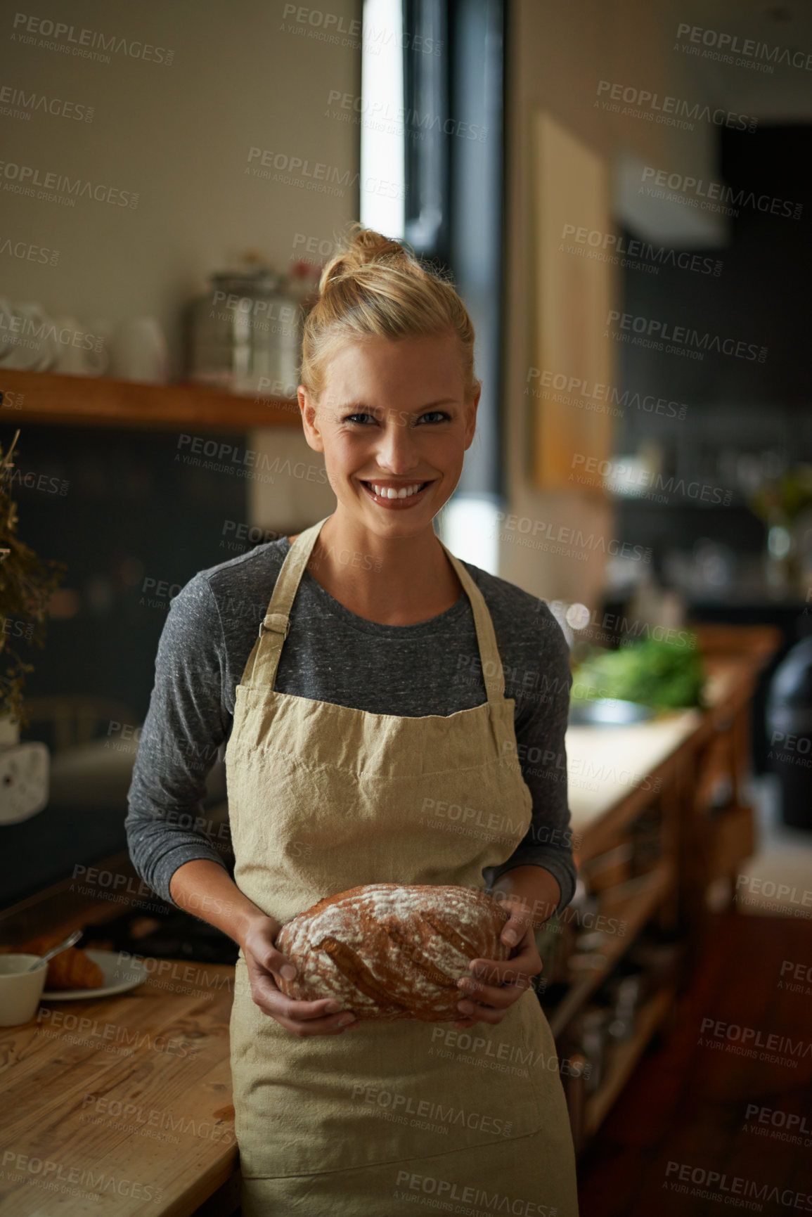 Buy stock photo Portrait of a young female baker holding homemade bread