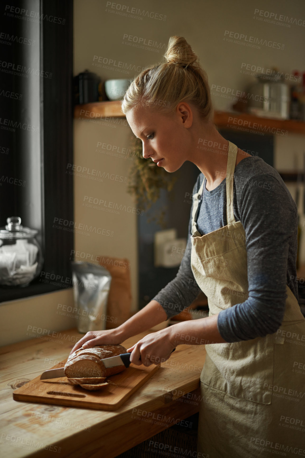 Buy stock photo Bakery, kitchen and woman with knife on bread, cutting on board and cooking gluten free food for breakfast. Fresh, loaf and chef in restaurant with healthy rye in preparation process of brunch