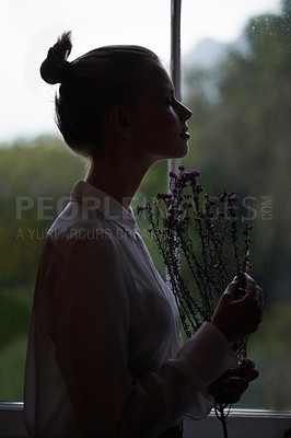 Buy stock photo Female person, flowers and window for in home, dark room and alone aesthetic for contemplation or artistic. Women, dim light and morning with thinking, creative and mysterious style for loneliness