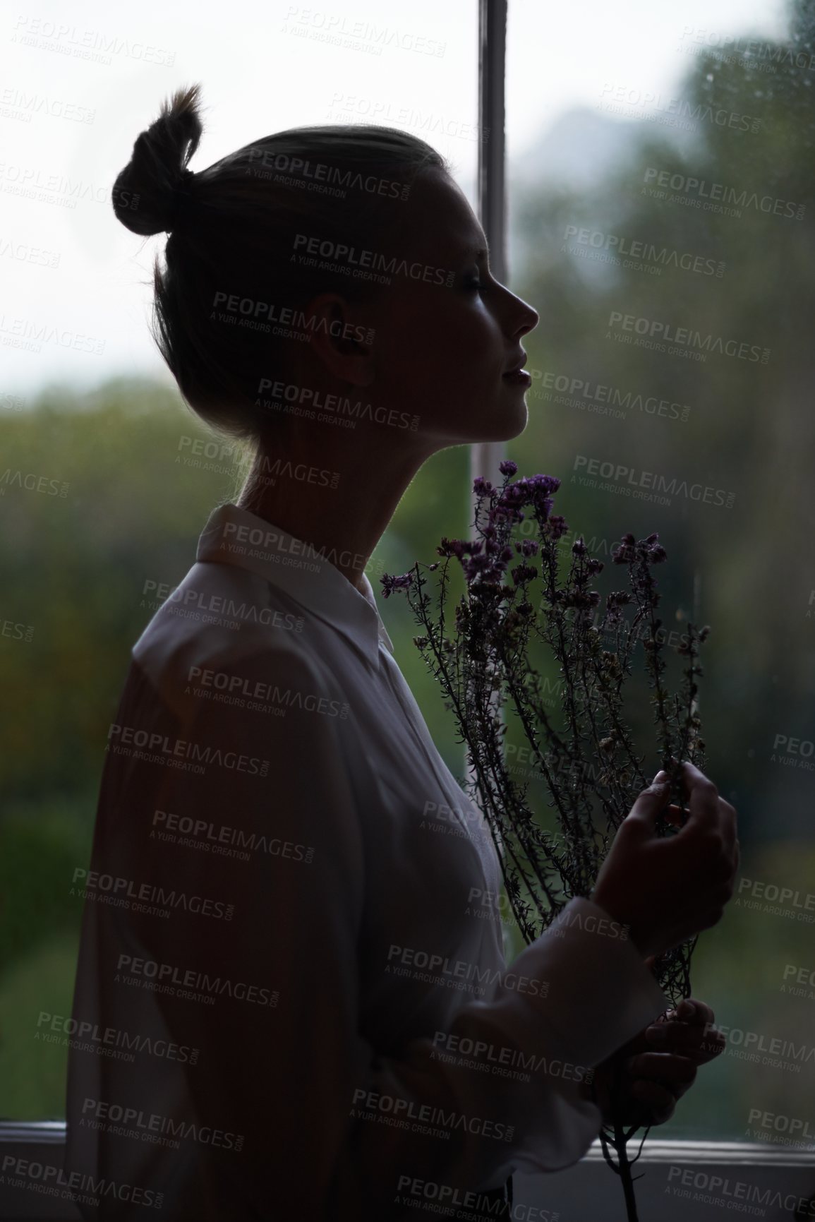 Buy stock photo Female person, flowers and window for in home, dark room and alone aesthetic for contemplation or artistic. Women, dim light and morning with thinking, creative and mysterious style for loneliness