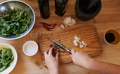 Buy stock photo Hands, chopping and ingredients in kitchen for salad preparation or walnuts, leafy greens or garlic. Person, knife and cooking vegan meal on wooden board with spices for nutrition, health or top view