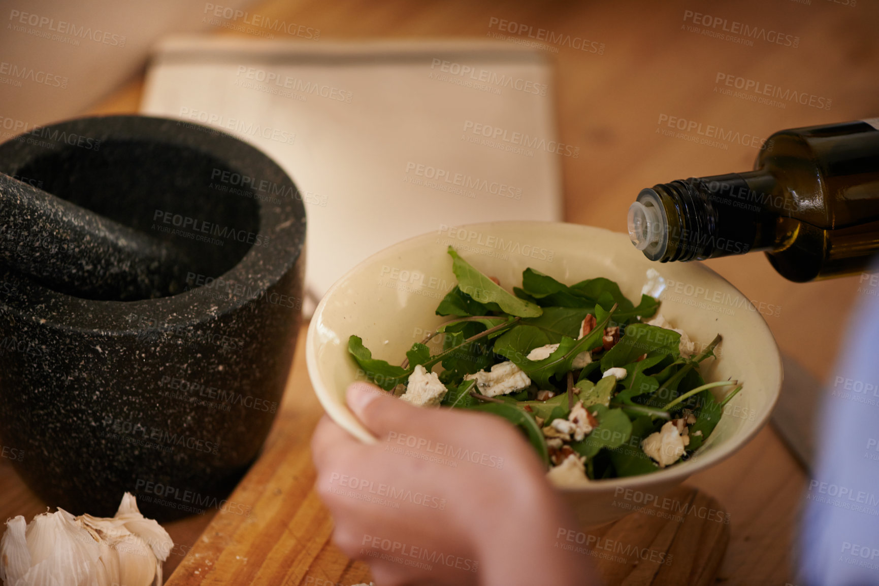 Buy stock photo Salad, olive oil and hand with bowl for healthy food, eating meal of leaves or lettuce with cheese in kitchen. Person cooking, hungry and preparing dish with ingredients, vegetables and dressing