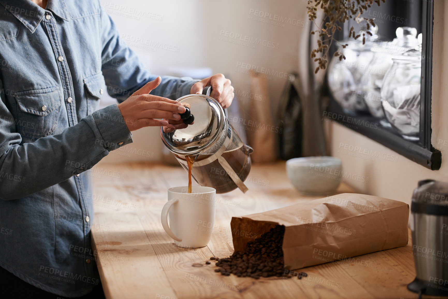 Buy stock photo A young woman making coffee