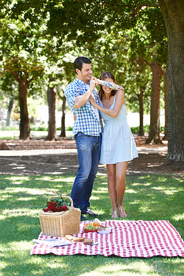 Buy stock photo Love, picnic and surprise with couple in park for romance, bonding and summer vacation. Happiness, commitment and relax with man and blindfold woman in nature for date, support and relationship