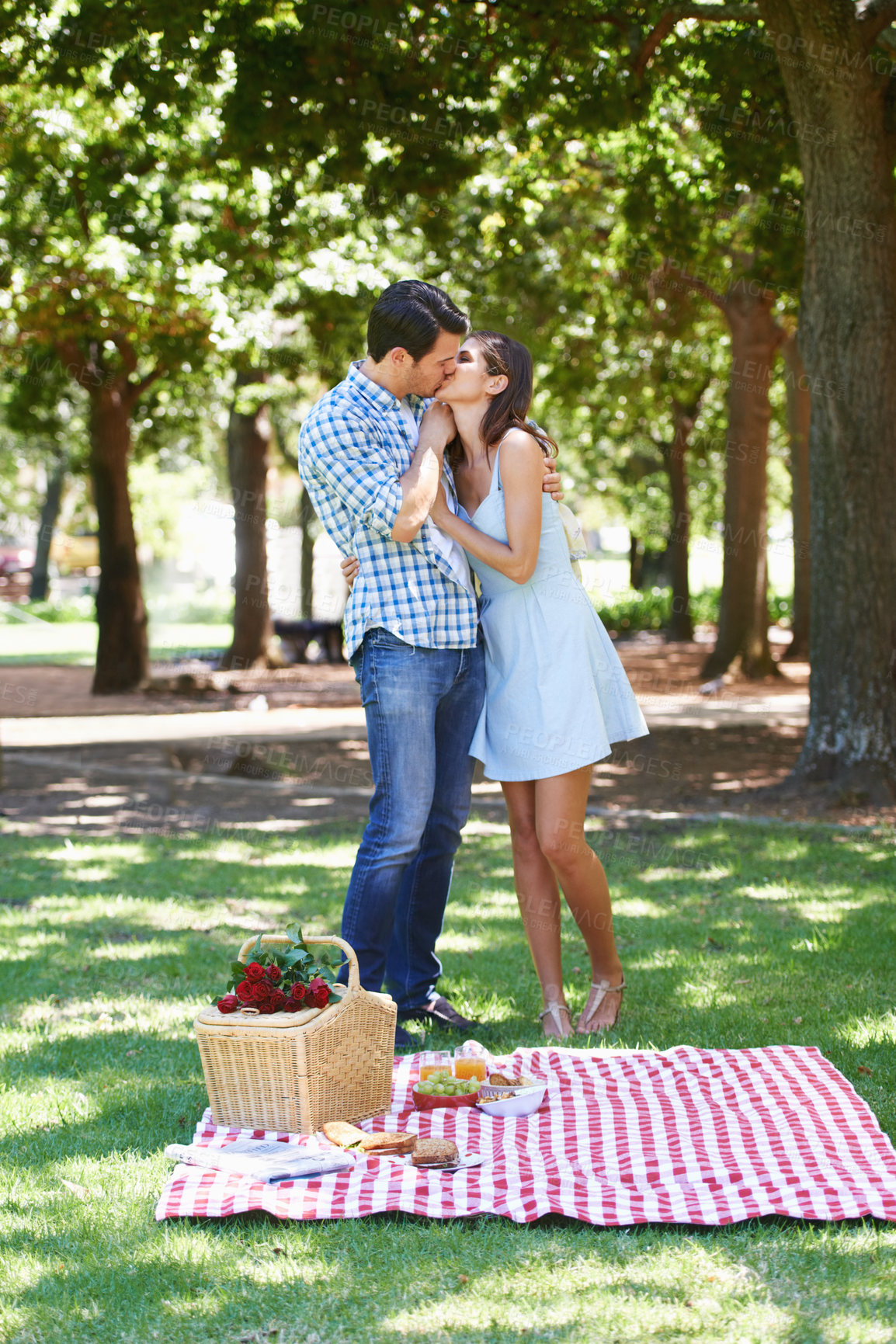 Buy stock photo Couple, park and kiss in nature at picnic with love under the trees and enjoying romance in the summer sun. Cheerful, special and outdoor as partners and bonding with trust, care and commitment