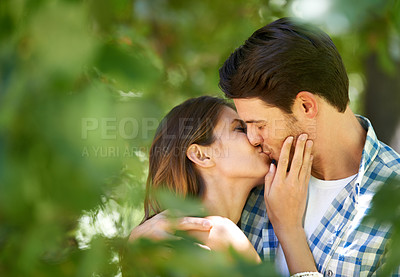 Buy stock photo Couple, garden and kiss with love for date, bonding and romance with embrace in nature park. Man, woman and happy relationship with affection in summer for vacation, weekend or travel together