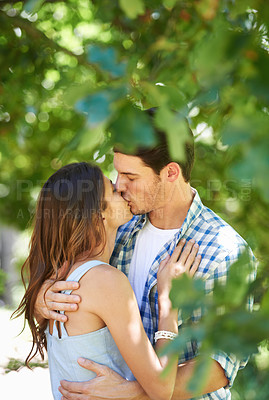 Buy stock photo Love, kiss and holiday with couple in park for romance, bonding and summer vacation. Affection, commitment and relax with man and woman hugging on date in nature for care, support and relationship