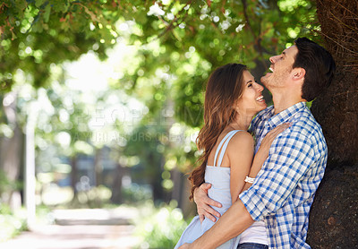 Buy stock photo Young couple, laughing and hug with love under the trees in the park and enjoying sunshine views in the summer sun. Cheerful, affection outdoor and romantic partners bonding with a nature lifestyle