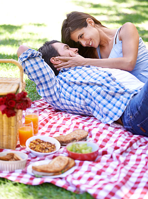 Buy stock photo A happy young couple enjoying a picnic in the summer sun