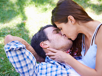 Buy stock photo Couple, kiss and picnic on grass for love, bonding and connection on holiday in park outdoors. Relax, man and woman with romance for healthy relationship, commitment and date on vacation in Miami