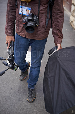 Buy stock photo Lighting, equipment and photographer in outdoor for photoshoot with camera lens and gear. Cameraman, walking and photography tools for press, project and person travel on street with reflector tech