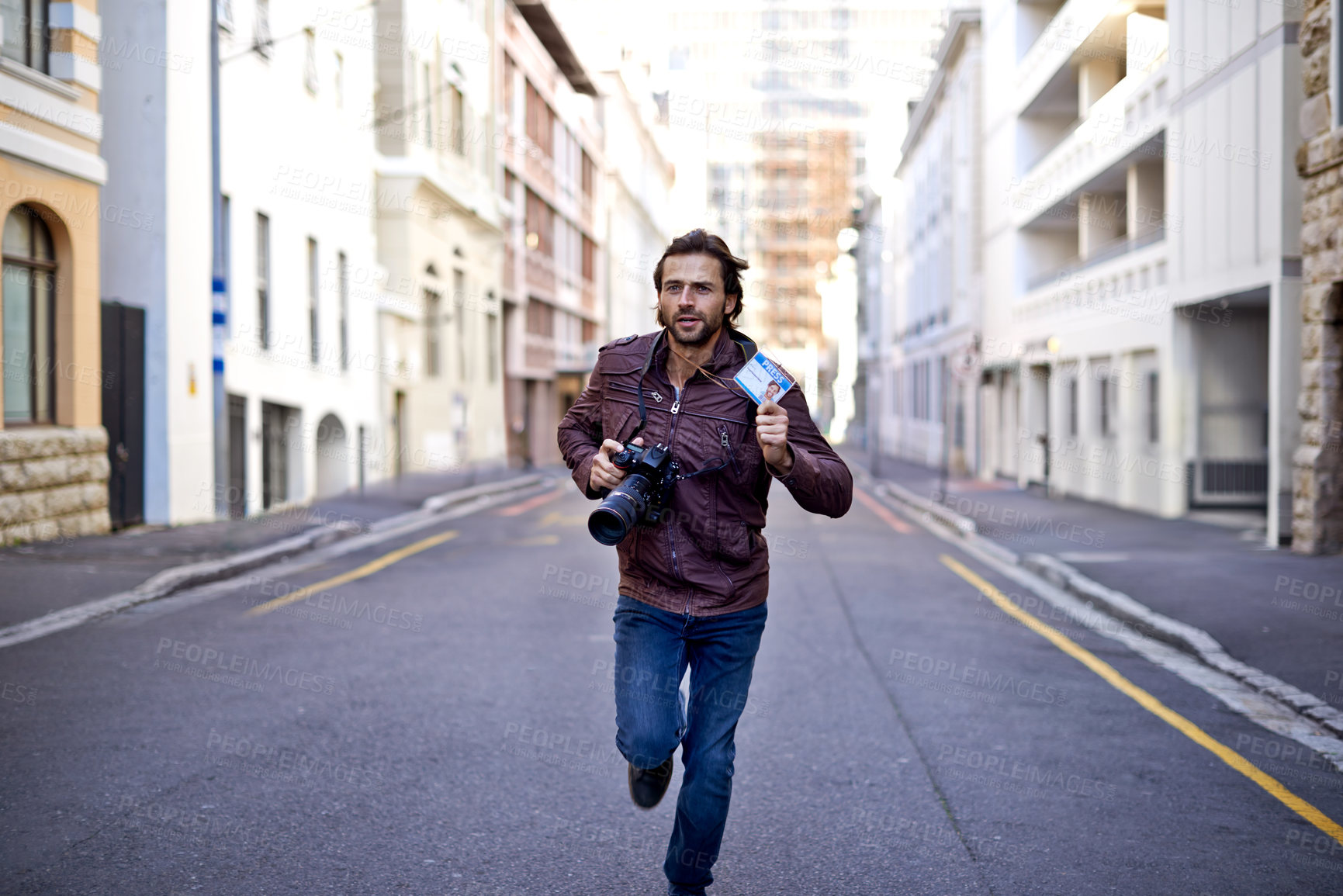 Buy stock photo A young photographer running to an event