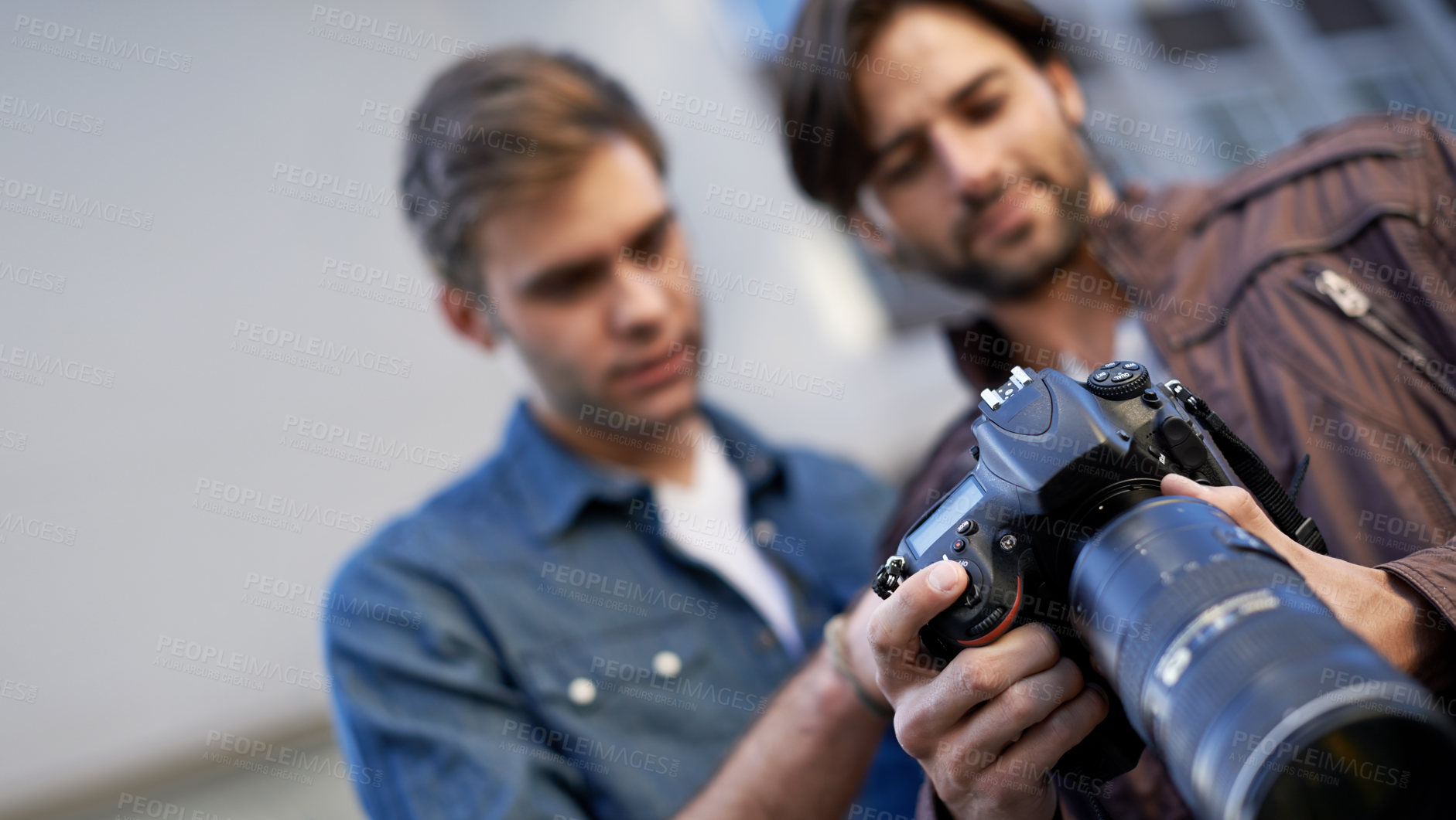 Buy stock photo Low angle shot of two men looking at the lcd screen on a digital camera