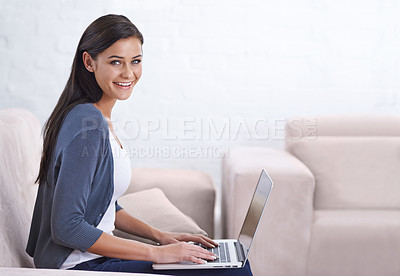 Buy stock photo A young woman working on her laptop at home