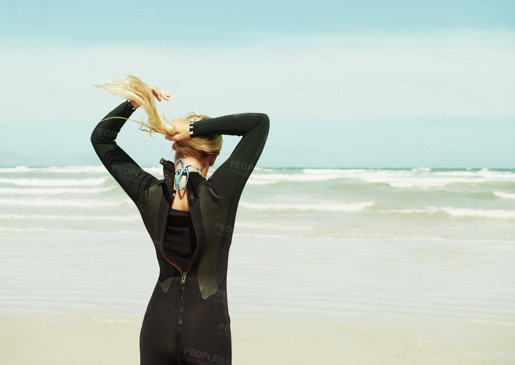 Buy stock photo A surfer girl tying her hair into a ponytail