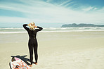 Tying back her hair for comfort during surfing