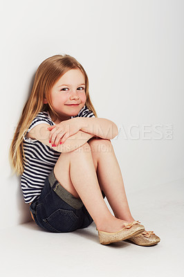 Buy stock photo Studio portrait of an adorable little girl sitting with her back against the wall