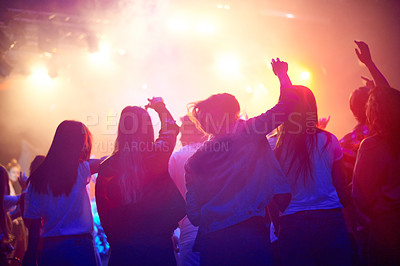 Buy stock photo Crowd, people dancing at concert or music festival from back, neon lights and energy at live event. Dance, fun and group of excited fans in arena at rock band performance or audience at rave party.