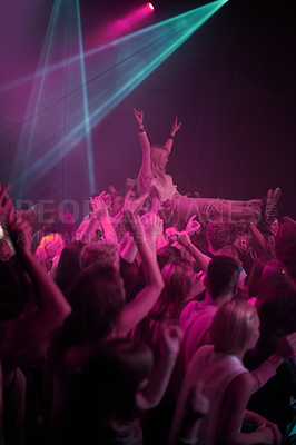 Buy stock photo Crowd surf, neon and people at music festival with neon pink lighting and energy at live concert event. Dance, fun and group of excited gen z fans in arena at rock band performance or audience party.