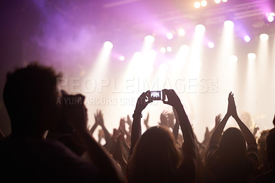 Buy stock photo Rearview shot of fans filming a band on stage