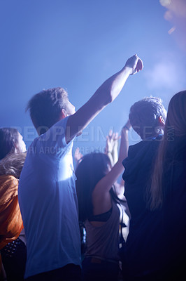 Buy stock photo Man in crowd, fans and dancing at concert, music festival and hands in air for energy or night event. Dance, fun or group of excited people in arena at rock band performance or audience rave party.