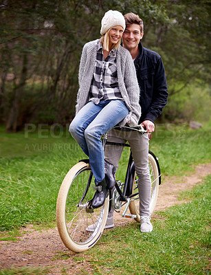 Buy stock photo A young couple enjoying a bike ride outdoors together
