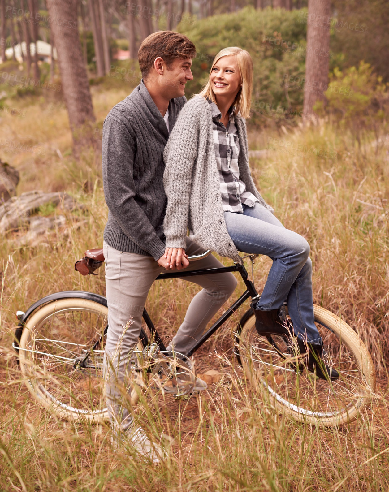 Buy stock photo A young couple enjoying a bike ride outdoors together