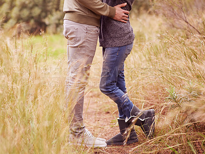 Buy stock photo Nature, legs and hug with couple in countryside together for romance, bonding or dating on field of grass. Love, earth or environment with man and woman embracing outdoor for anniversary closeup