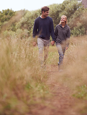 Buy stock photo Happy couple, walking or holding hands in the countryside, nature or summer outdoor for hiking on valentines day date. Smile, man and woman at meadow for support, love or romantic connection together