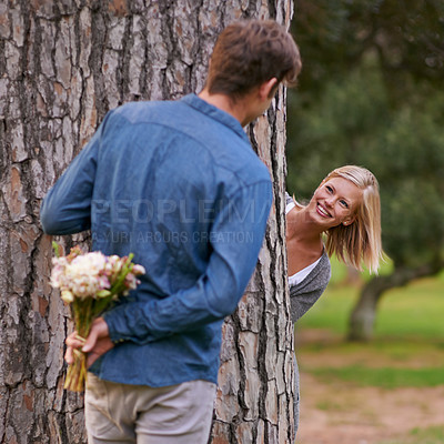 Buy stock photo Couple, park and love for valentines day with flower in romance, boyfriend for girlfriend. Romantic, outdoor and date to play with hide and seek for bonding, happiness and relax for wellness 