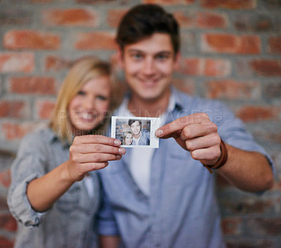 Buy stock photo Hands, photograph and couple on wall blurred background together for love, bonding of memory of past. Portrait, smile or happy with young man and woman holding picture for romance or nostalgia