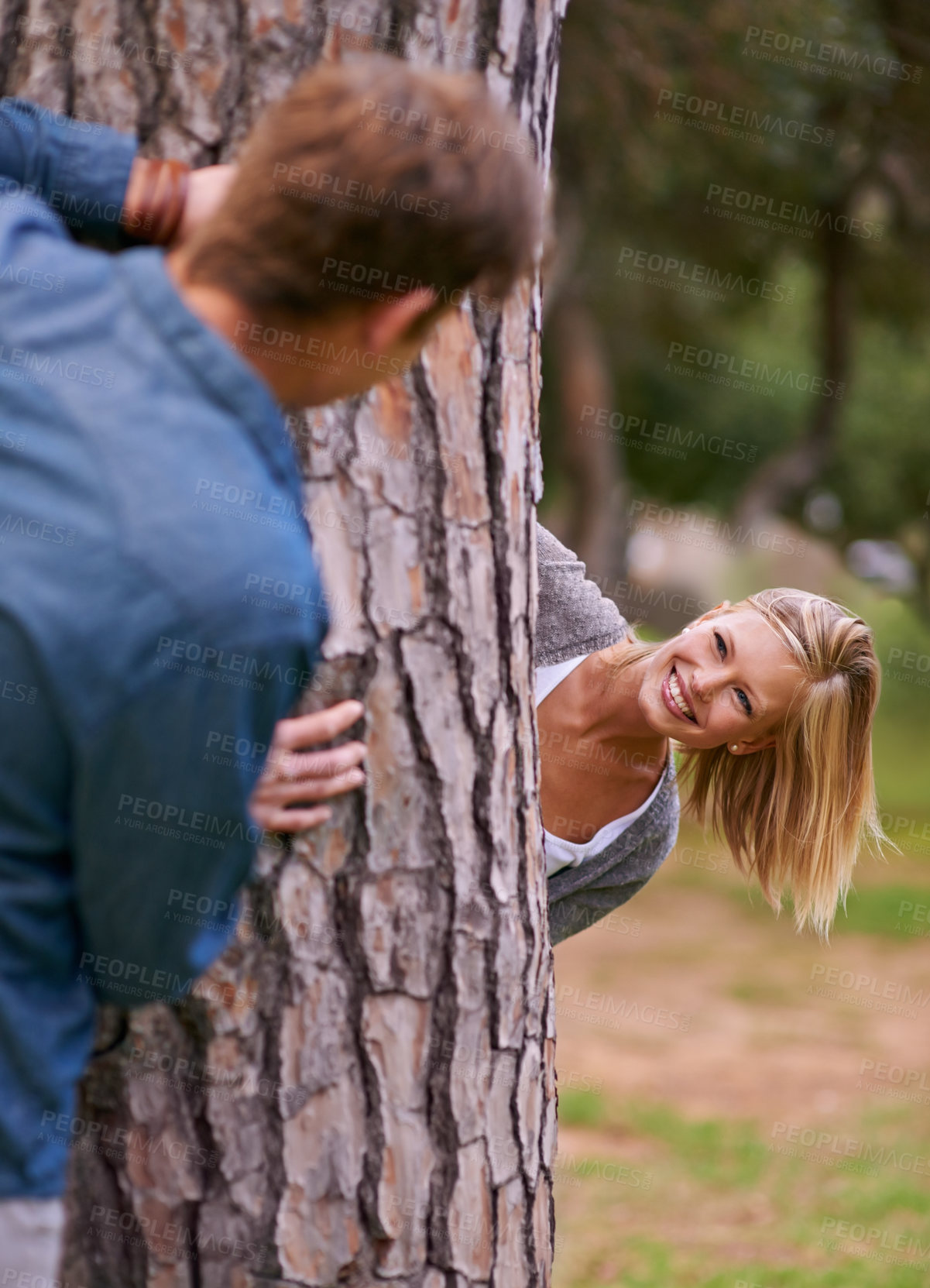 Buy stock photo Couple, park and smile with playing for hide and seek, love and happiness in outdoor setting in Los Angeles. Relationship, romance and fun day in forest for lifestyle, wellness and relax for bonding