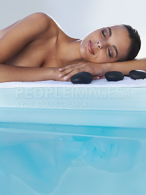 Buy stock photo A refreshed young woman lying beside the pool at a spa