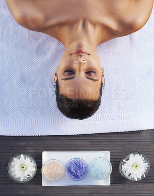 Buy stock photo A gorgeous young woman lying on her back with aromatherapy salts