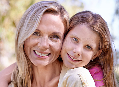 Buy stock photo A smiling mother with her daughter on her back  while outdoors