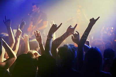Buy stock photo Hands in air, people dancing at concert or music festival with neon lights and energy at live event. Dance, fun and excited crowd of fans in arena for rock band, musician performance and spotlight.