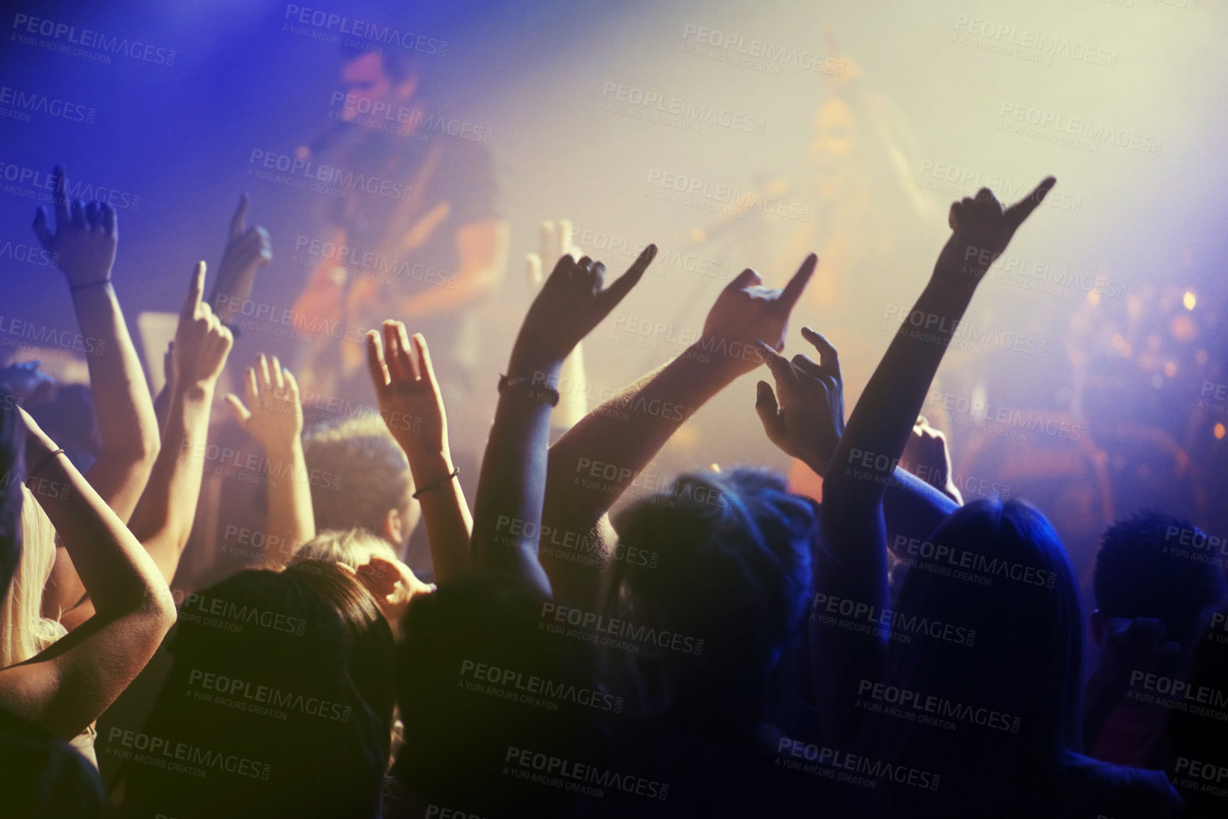 Buy stock photo Hands in air, people dancing at concert or music festival with neon lights and energy at live event. Dance, fun and excited crowd of fans in arena for rock band, musician performance and spotlight.