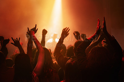 Buy stock photo Hands of people in crowd dancing at concert or music festival, neon lights and energy at live event. Dance, applause and group of excited fans in silhouette at rock band performance with lighting.